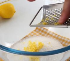 someone grating lemons in a glass bowl