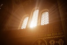 sunlight shining through the windows in an ornate building