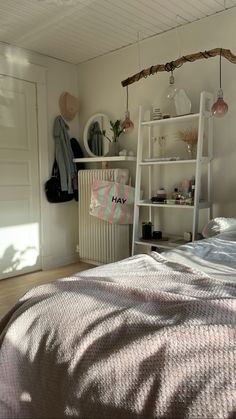 a bedroom with a ladder hanging from the ceiling and a bed in front of it