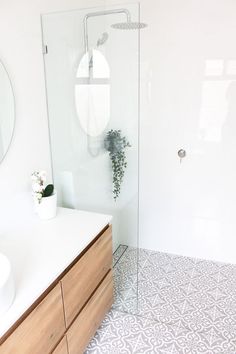 a bathroom with a sink, mirror and shower stall in the middle of the room