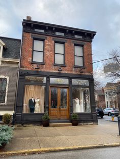 an old brick building with two mannequins in the window