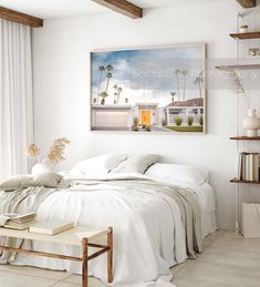 a bedroom with a bed, book shelf and pictures on the wall above it in white