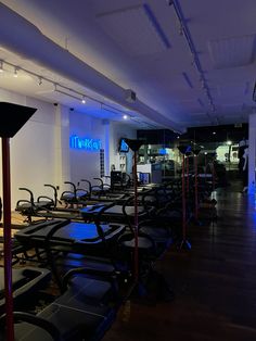 there are many treadmills lined up in the room with blue lights on them