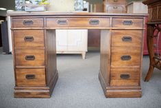 an old wooden desk with drawers in a store