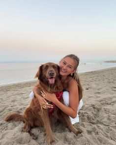 a woman hugging her dog on the beach