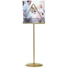 a metal stand with a gold triangle on it and a white photo in the middle