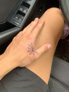 a person with a spider web tattoo on their left foot sitting in a car seat