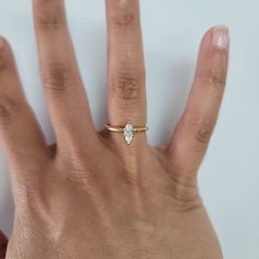 a person's hand with a diamond ring on top of their thumb and fingers