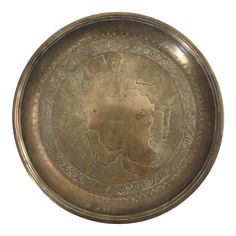 an old brass plate with ornate designs on it