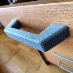 a close up of a drawer handle on a wooden cabinet