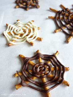 three different types of chocolate and pretzels on a sheet of paper with brown and white icing