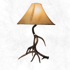 an antler lamp with a brown shade on it's base and a white background