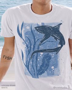 "This thresher shark t-shirt is great for shark, beach, and marine life lovers. Great gift for anyone who spends their time enjoying the surf, beach sunsets, snorkeling, scuba diving, and other water activities. FABRIC CONTENT:  - Fabric content varies based on color. Solid colors are 100% cotton, heather colors are 52% cotton/48% polyester, Athletic Heather and Black Heather are 90% cotton/10% polyester) - Light fabric (4.2 oz/yd² (142 g/m   FIT & CONSTRUCTION :  - Runs true to size (sizing runs slightly larger for women, as this is a unisex style) - Side seams help hold the garment's shape longer and give structural support - Highly elastic ribbed knit collar and neck seam helps retain neck shape  - Reinforced shoulder and neck seams stabilize the back of garment and prevents stretching Shark Graphic Tee, Shark Shirt Design, Shark Shirt Aesthetic, Sharkcore Outfits, Ocean Clothes, Shark Clothes, Shark Outfit, Shark Shirts, Shark Stuff