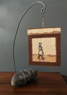 a rock sitting on top of a wooden table next to a lamp with a person in it