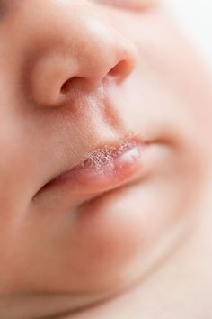 a close up of a baby's nose with it's tongue sticking out