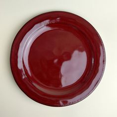 a red plate on a white table with a black border around the edge and bottom