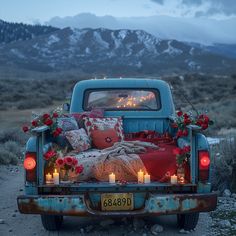 an old pickup truck with candles in the bed and pillows on it's back