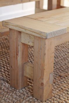 a wooden bench sitting on top of a rug