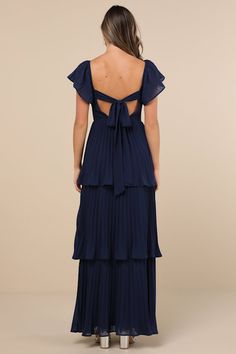 Everyone will instantly notice your sensational sense of style when you strut in wearing the Lulus Notorious Charm Navy Blue Pleated Flutter Sleeve Maxi Dress! Airy, pleated woven chiffon shapes this gorgeous dress that features a lightly gathered bodice with a sweetheart neckline and long sashes that secure atop an otherwise open back, framed by fluttery short sleeves (with elastic at the shoulders). The high, fitted waist tops a flowy, tiered A-line skirt that cascades down to a sweeping maxi hem. Hidden back zipper/clasp. Fit: This garment fits true to size. Length: Floor length. Size medium measures 53.75" from shoulder to hem. Bust: Great for any cup size. Waist: Fitted - very fitted at natural waist. Hip: Not Fitted - room for hips. Undergarments: May be worn with an adhesive bra, pe Formal Dresses Floor Length, Navy Blue Dresses Long, Formal Dress Mid Size, Long Navy Blue Dress Outfit Casual, Navy Wedding Bridesmaid Dresses, Bridesmaid Dresses Blues, Floral Blue Bridesmaid Dresses, Long Sleeved Dress Formal, Royal Blue Wedding Guest Dress