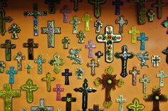 a wall covered in lots of different colored crosses