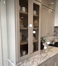 a kitchen with marble counter tops and white cabinets