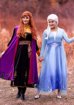 two women dressed as disney princesses holding hands