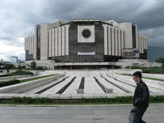 a man is walking in front of a building