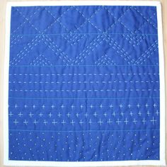 a blue quilt with white stitching on it