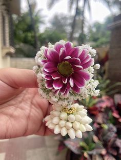 a person is holding a flower in their hand