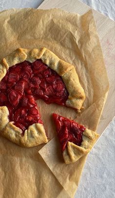 a piece of pie on top of wax paper with one slice missing from the pie