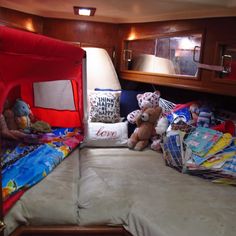 there is a bed with stuffed animals on it in the room that looks like a boat