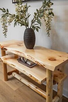 a wooden table with two benches and a vase on top