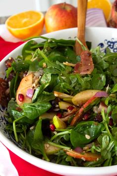 a salad in a bowl with apples and oranges