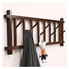 a teddy bear is hanging on the wall next to a towel rack and coat rack