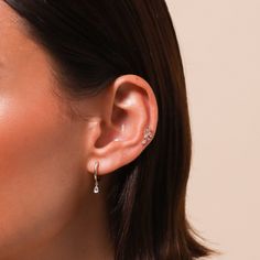 a close up of a woman's ear with diamond earrings on her left side