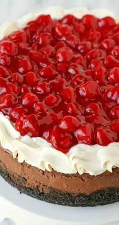 a cake with cherries on top is sitting on a plate