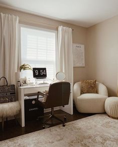 a bedroom with a chair, desk and computer on the table in front of a window