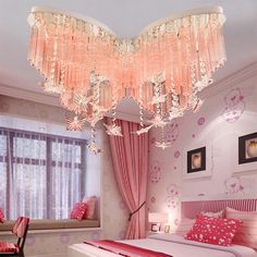 a pink bedroom with chandelier above the bed