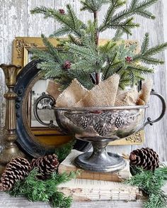 a christmas centerpiece with pine cones and burlocks in it on top of a table