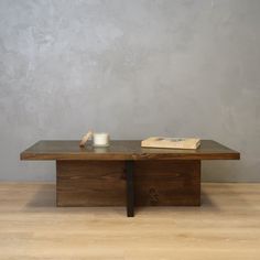 a wooden table sitting on top of a hard wood floor next to a gray wall