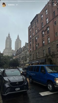 several cars are parked on the street in front of tall buildings