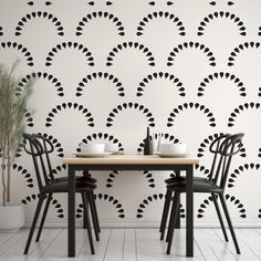 two chairs sitting at a table in front of a wall with black circles on it