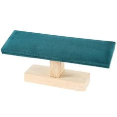 a wooden stand with a green cushion on it's top and one piece of wood in the middle