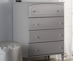 a gray dresser sitting next to a window