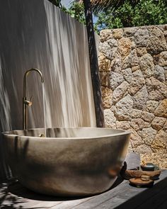 a stone bathtub sitting next to a wall