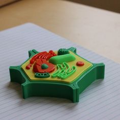 a close up of a plastic toy on top of a notepad with writing paper