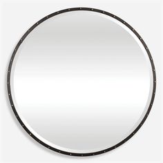 a round mirror with black trim around the edges and dots on the edge, in front of a white background