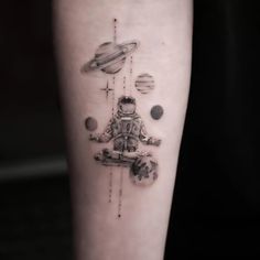 a tattoo on the leg of a person with an astronaut and planets in space behind it