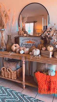 a wooden table topped with lots of different types of pumpkins and gourds