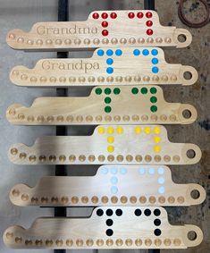 four wooden peg board game pieces with colored dots and the word grandma written on them